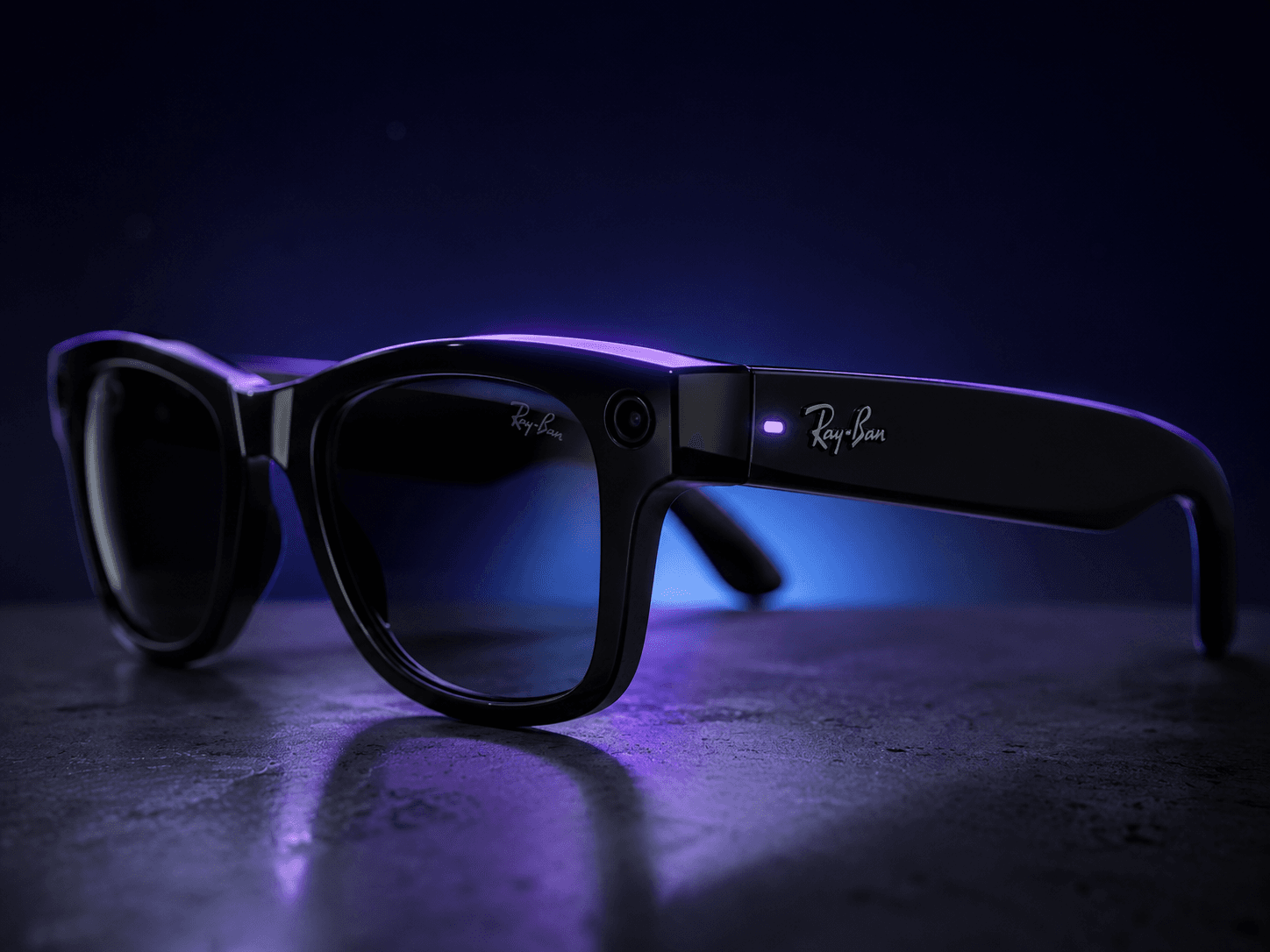 Ray-Ban Meta glasses, lit in cinematic blue and purple, sitting on a concrete surface.